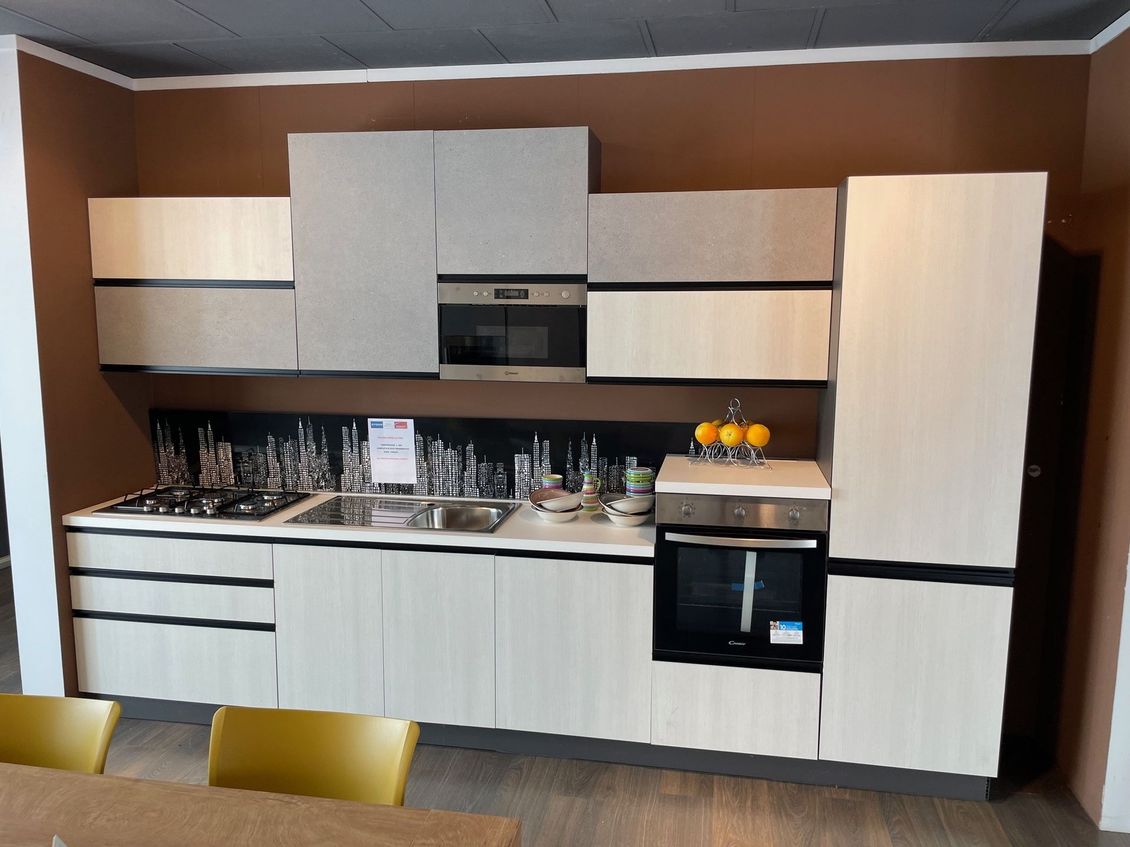 Una cucina con mobili bianchi ed elettrodomestici in acciaio inossidabile