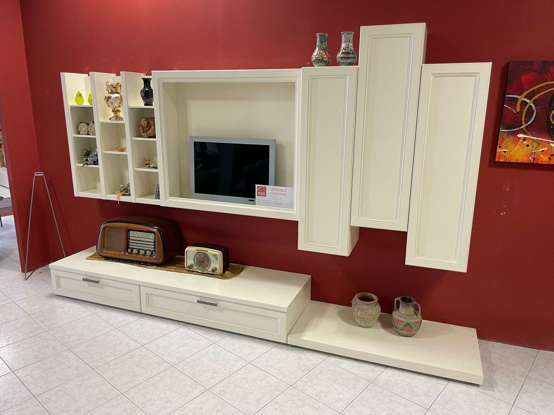 Un soggiorno con televisione, radio, vasi e un quadro sul muro.