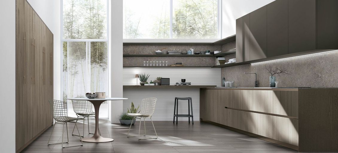 Una cucina con tavolo e sedie e un'ampia finestra.