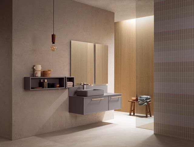 Un bagno con lavandino, specchio e armadietti.