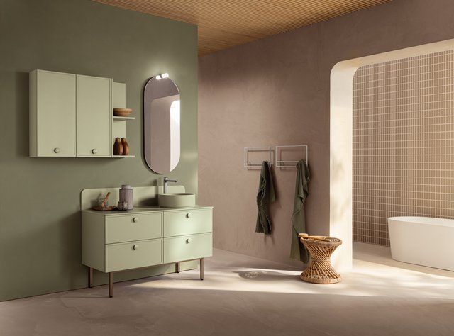 Un bagno con lavandino, specchio, armadietti e vasca da bagno.