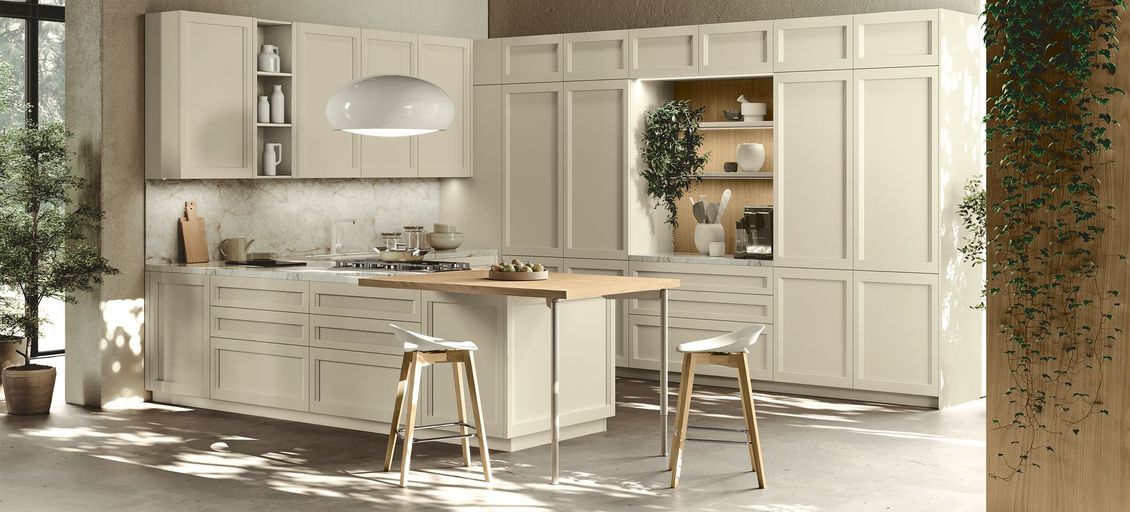 Una cucina con mobili e sgabelli bianchi e una grande isola.