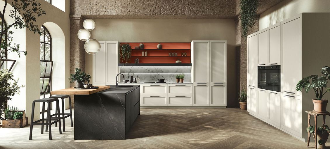 Una cucina con mobili bianchi e un'isola nera al centro.