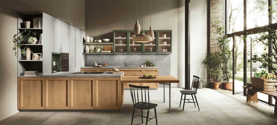 Una cucina con mobili in legno, tavolo e sedie.