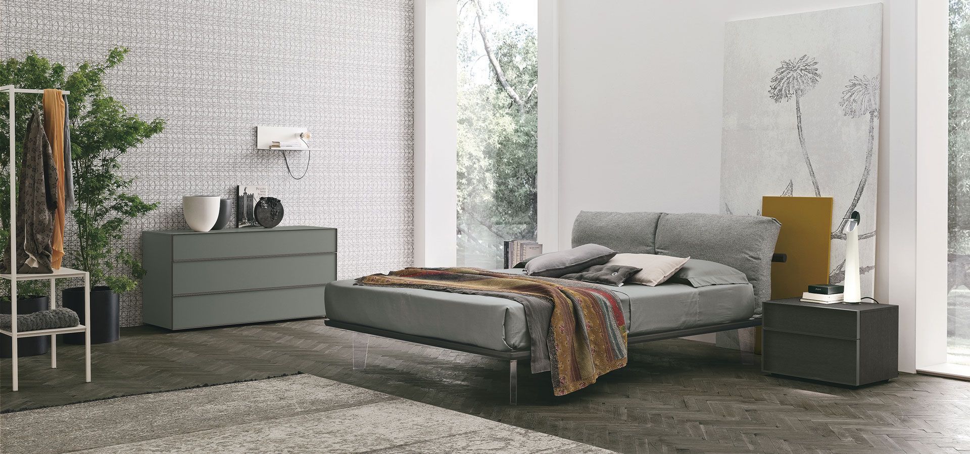 Una camera da letto con un letto, una cassettiera, un comodino e un tappeto.