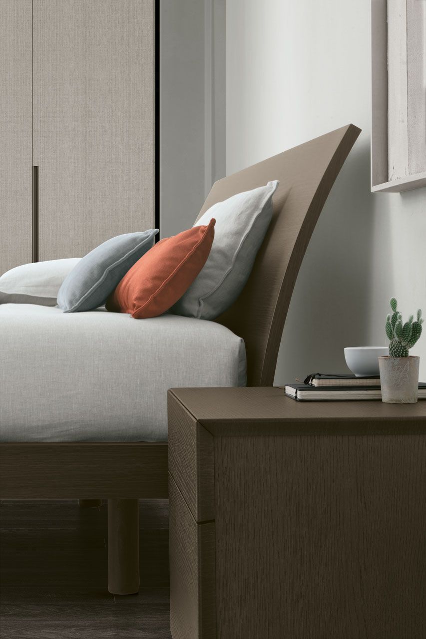 Una camera da letto con un letto e un comodino con una pianta sopra