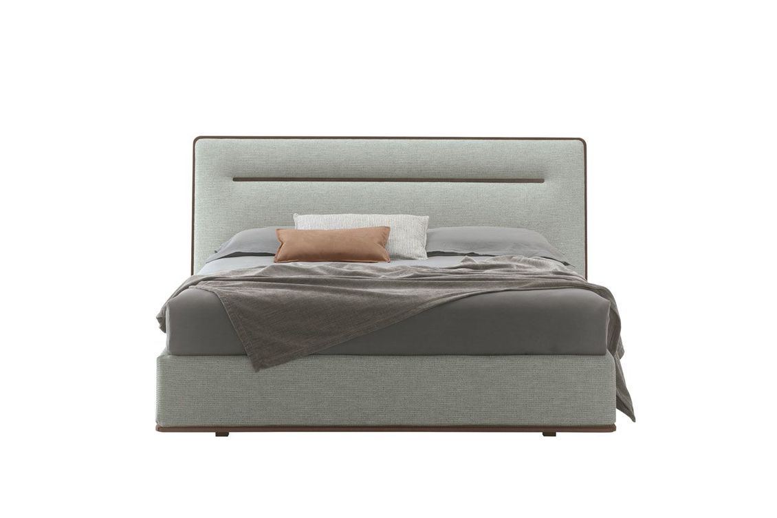Un letto con testiera e cuscini