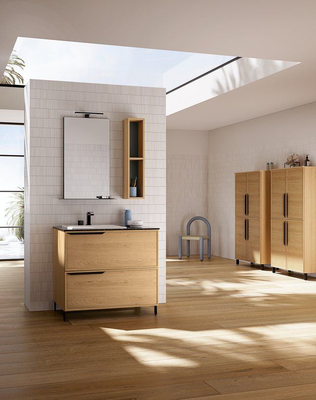 Un bagno con lavandino, specchio e armadietti