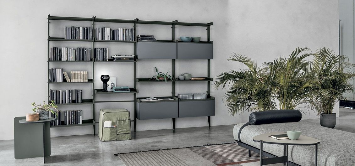 Un soggiorno con una libreria e un divano.