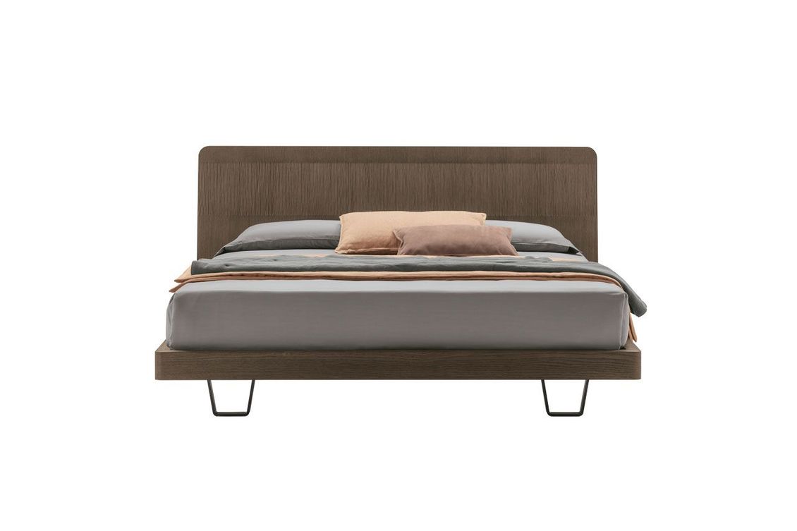 Un letto con testiera in legno e materasso su sfondo bianco