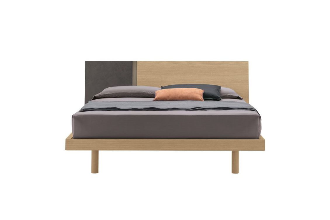Un letto con struttura in legno e materasso grigio su sfondo bianco.