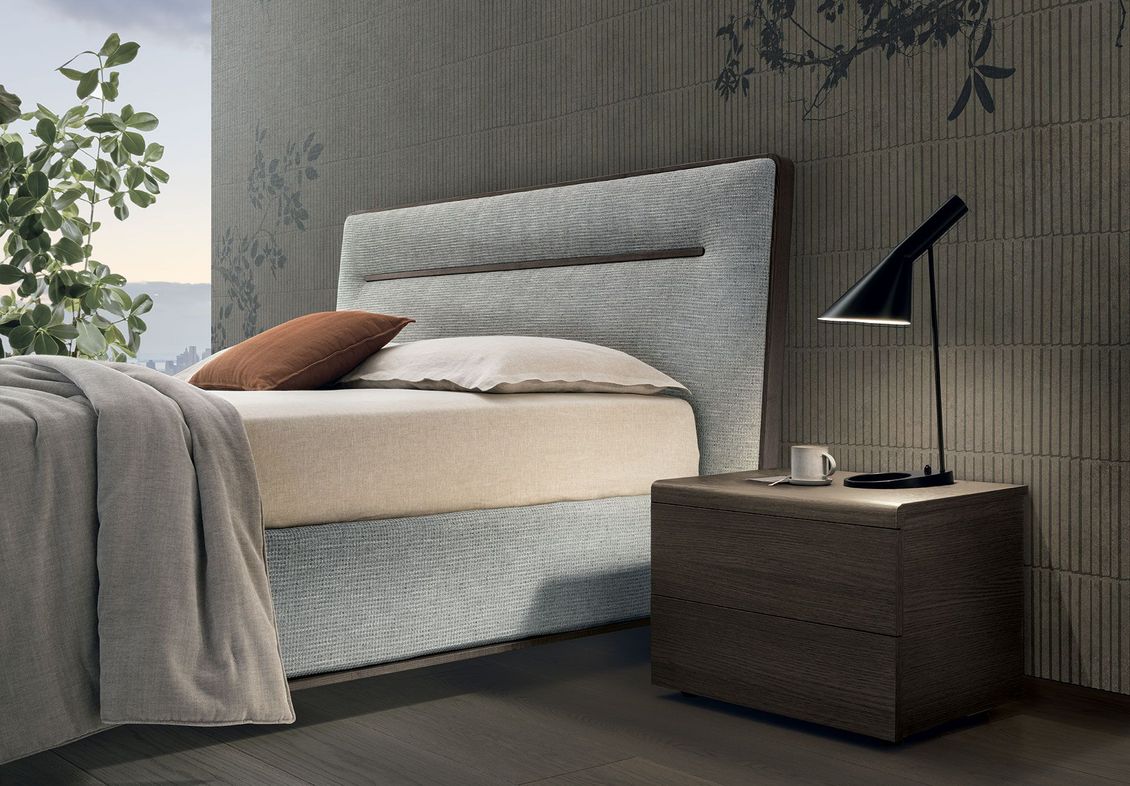 Una camera da letto con un letto, un comodino e una lampada