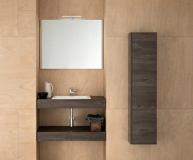 Un bagno con un lavandino, uno specchio e un mobile alto