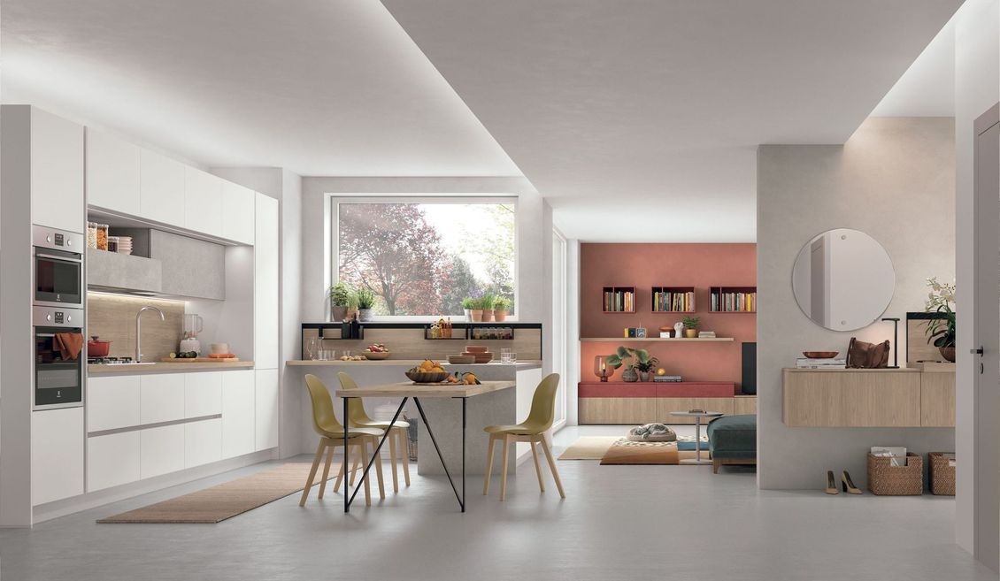 Una cucina con mobili bianchi, tavolo e sedie.