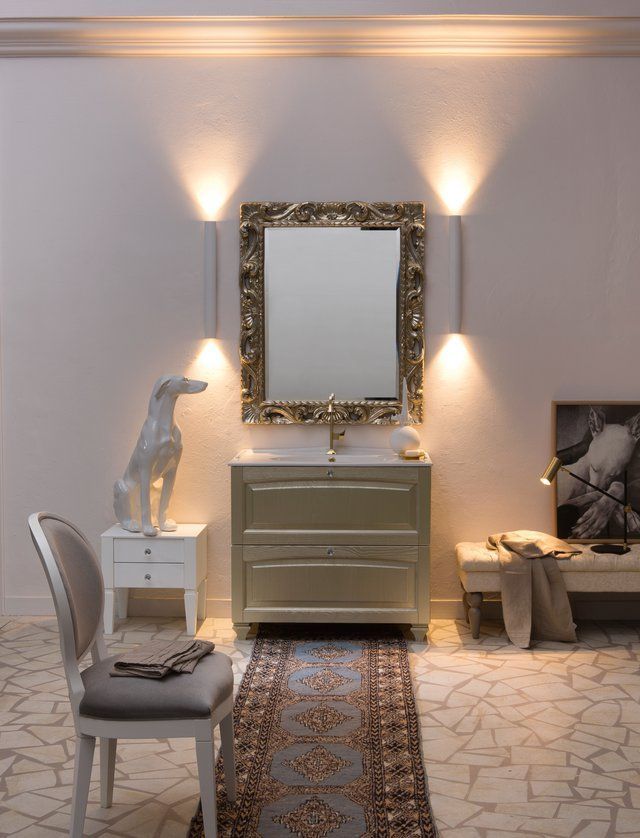 Un bagno con un lavandino uno specchio e una statua di un cane
