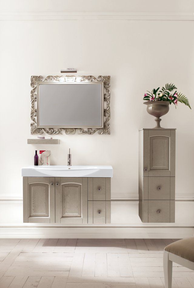 Un bagno con un lavandino uno specchio e un vaso di fiori