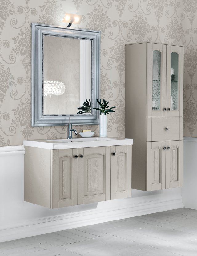 Un bagno con un lavandino, uno specchio e degli armadietti
