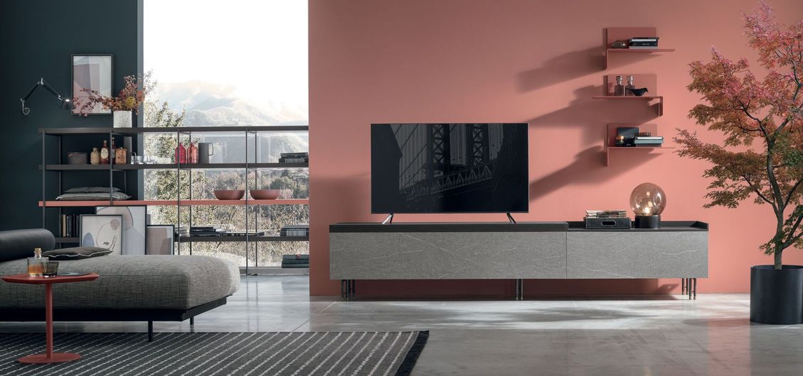 Un soggiorno con divano, televisione e scaffali.