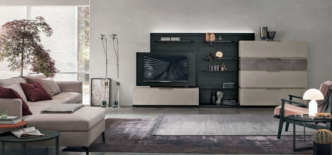 Un soggiorno con un divano e una televisione sulla parete.
