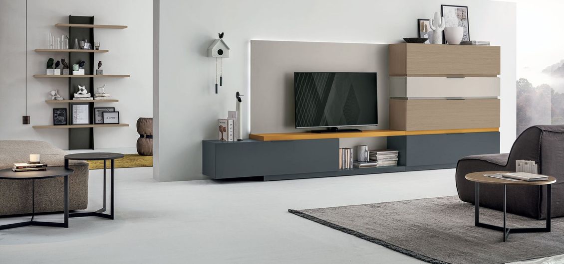 Un soggiorno con un divano e una televisione sul muro