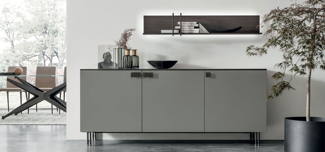 Una sala da pranzo con una credenza grigia e una pianta.