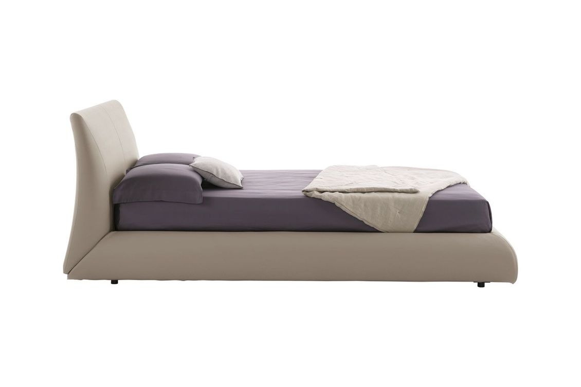 Un letto con materasso e cuscini viola su sfondo bianco.
