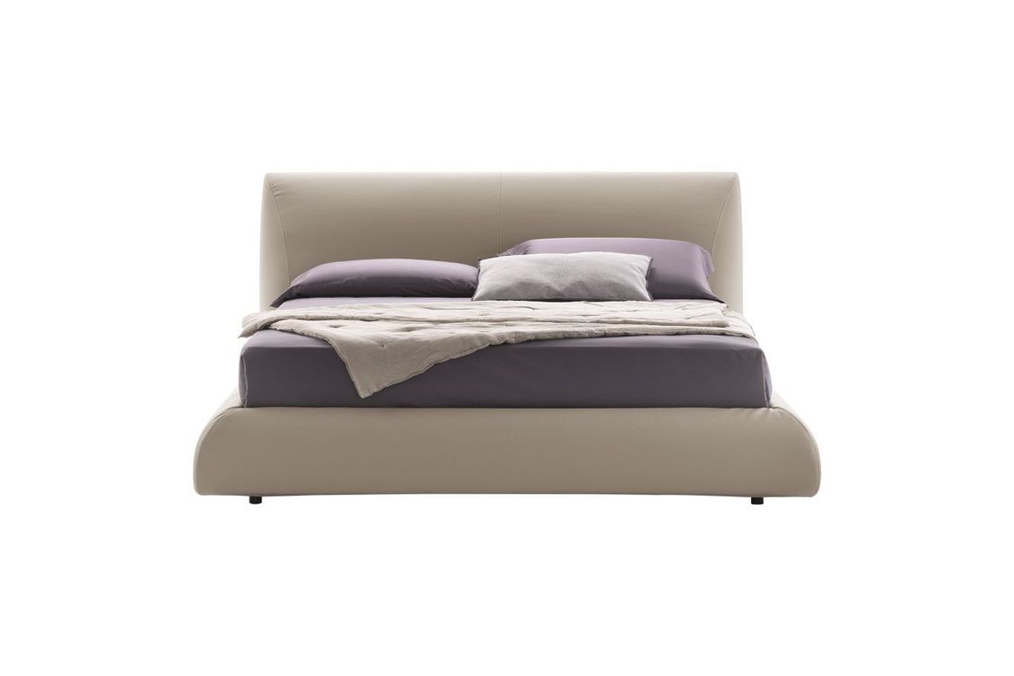Un letto con lenzuola e cuscini viola su uno sfondo bianco.