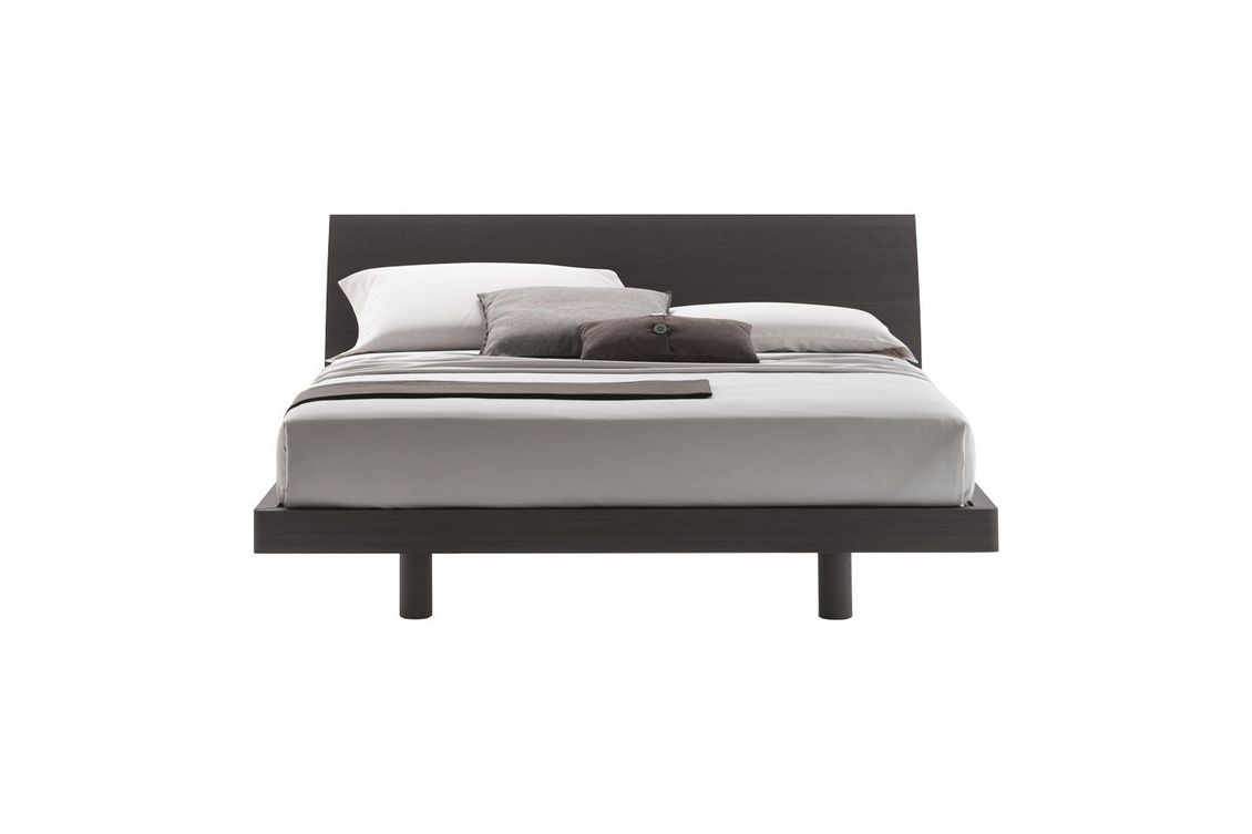 Un letto con lenzuola e cuscini bianchi su uno sfondo bianco.