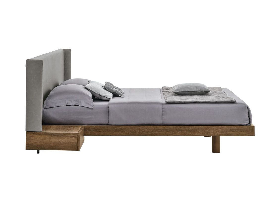 Un letto con un comodino sottostante su uno sfondo bianco.
