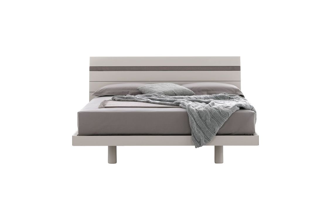 Un letto con una coperta sopra su uno sfondo bianco.