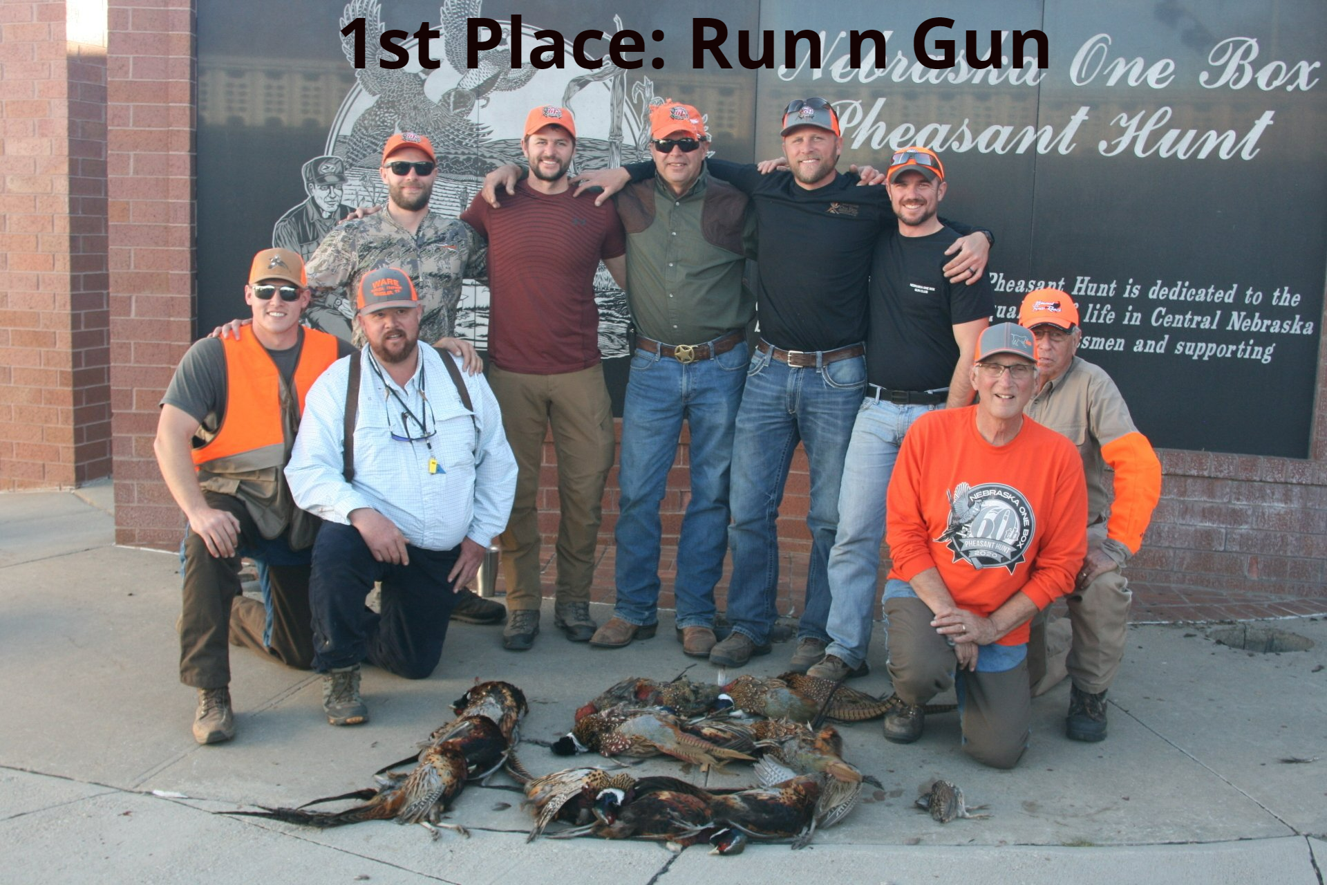 Group of men with pheasants, celebrating their win in a pheasant hunt.