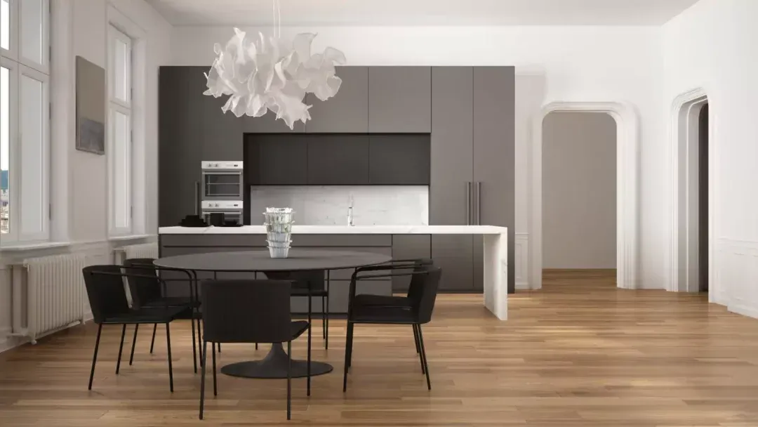 Modern kitchen and dining area with gray cabinets, a white island, and a round black table with chairs.