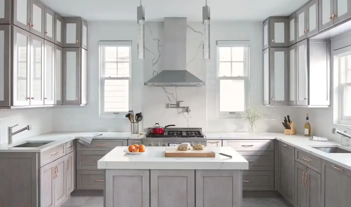 Modern kitchen with gray cabinets, white countertops, and a central island.