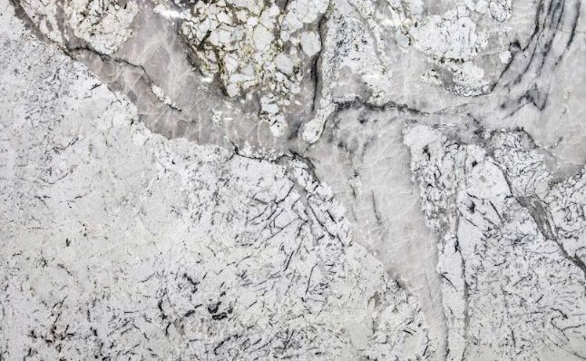 White and gray marble surface with dark veining and cracked texture