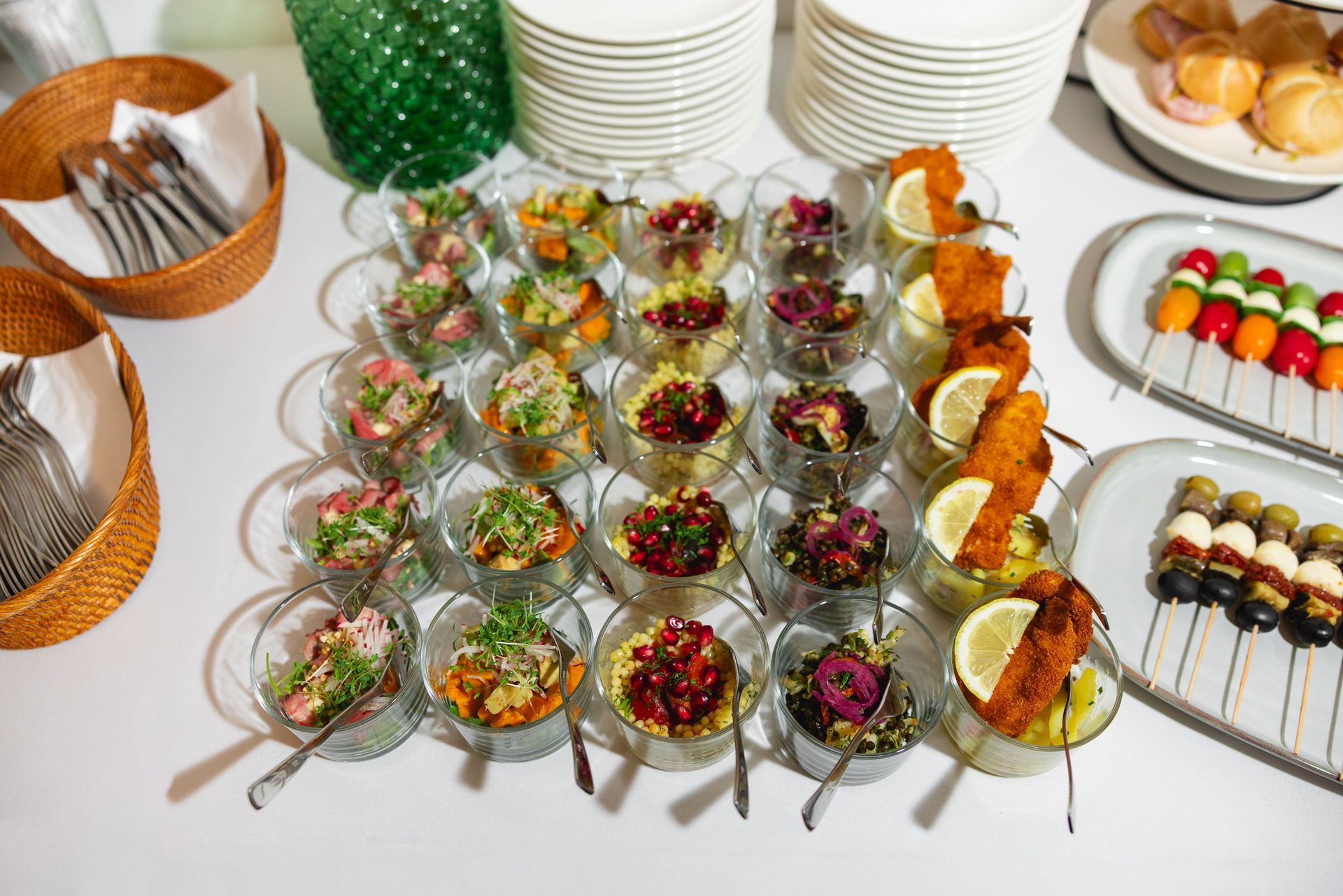 Buffet mit verschiedenen Horsd’œuvres in Gläsern, Obstspießen und Brotkörben