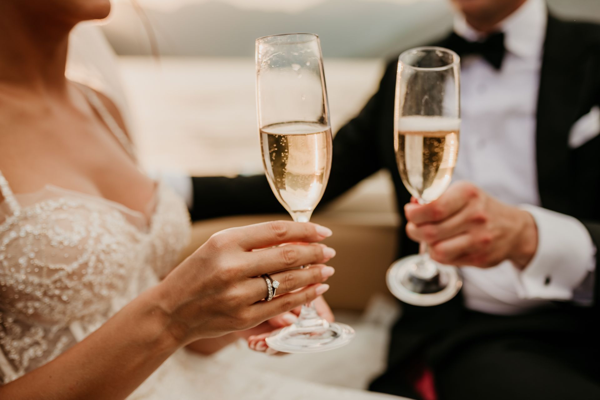 Ein Paar in Hochzeitskleidung stößt bei einem Empfang mit Champagnergläsern an.