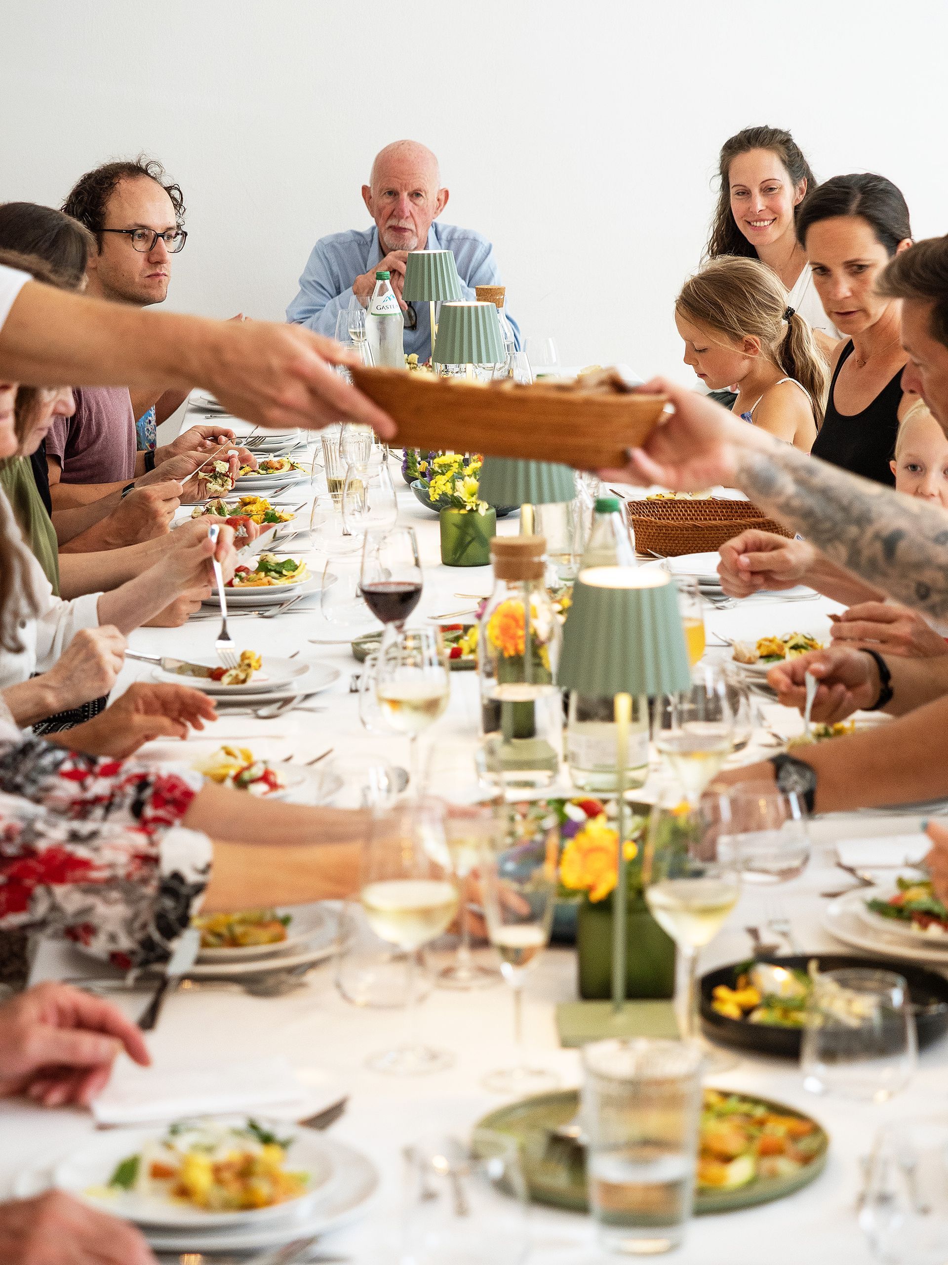 Menschen teilen sich eine Mahlzeit an einem langen, reich gedeckten Esstisch