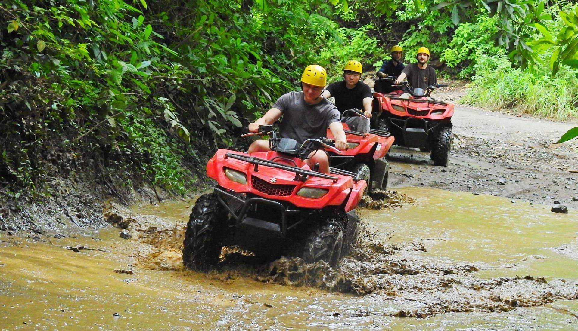 ATV tour excursion in Guanacaste Costa Rica riding through tropical off-road trails and muddy terrain on an adventure