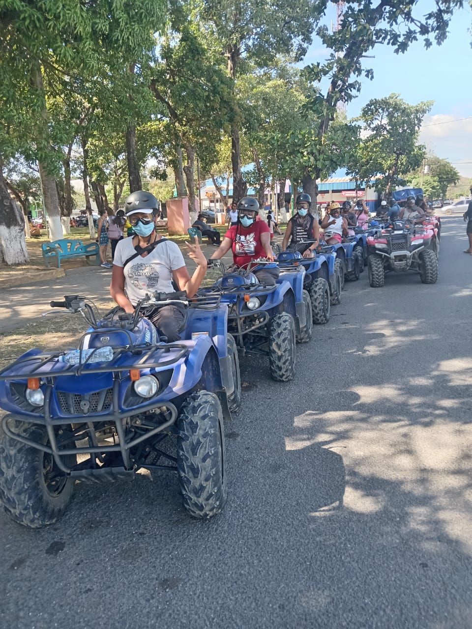 ATV group tour in Guanacaste Costa Rica with riders exploring local roads and tropical scenery on an adventure excursion