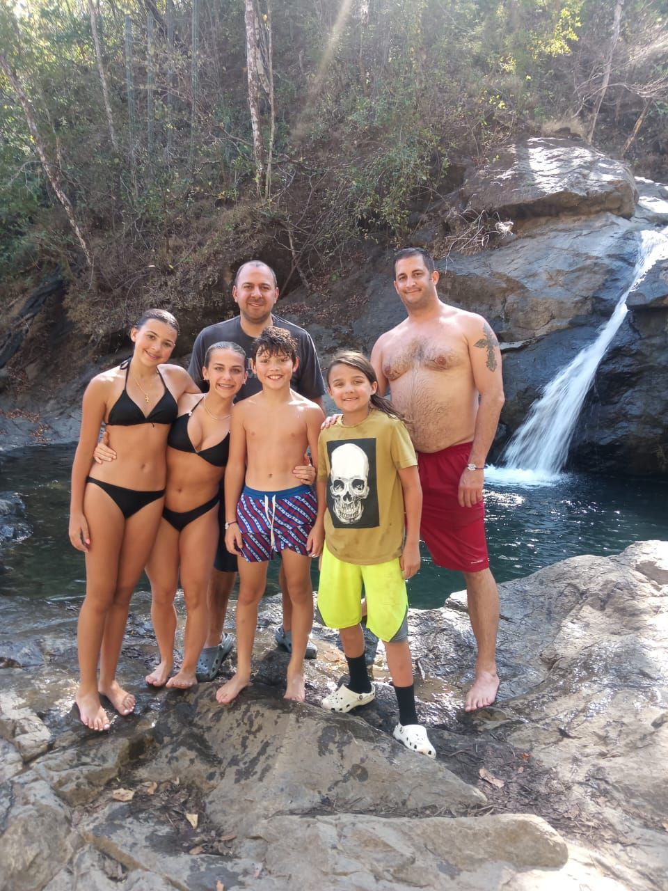 Family enjoying a waterfall during a personalized private excursion from El Mangroove Costa Rica in Guanacaste.