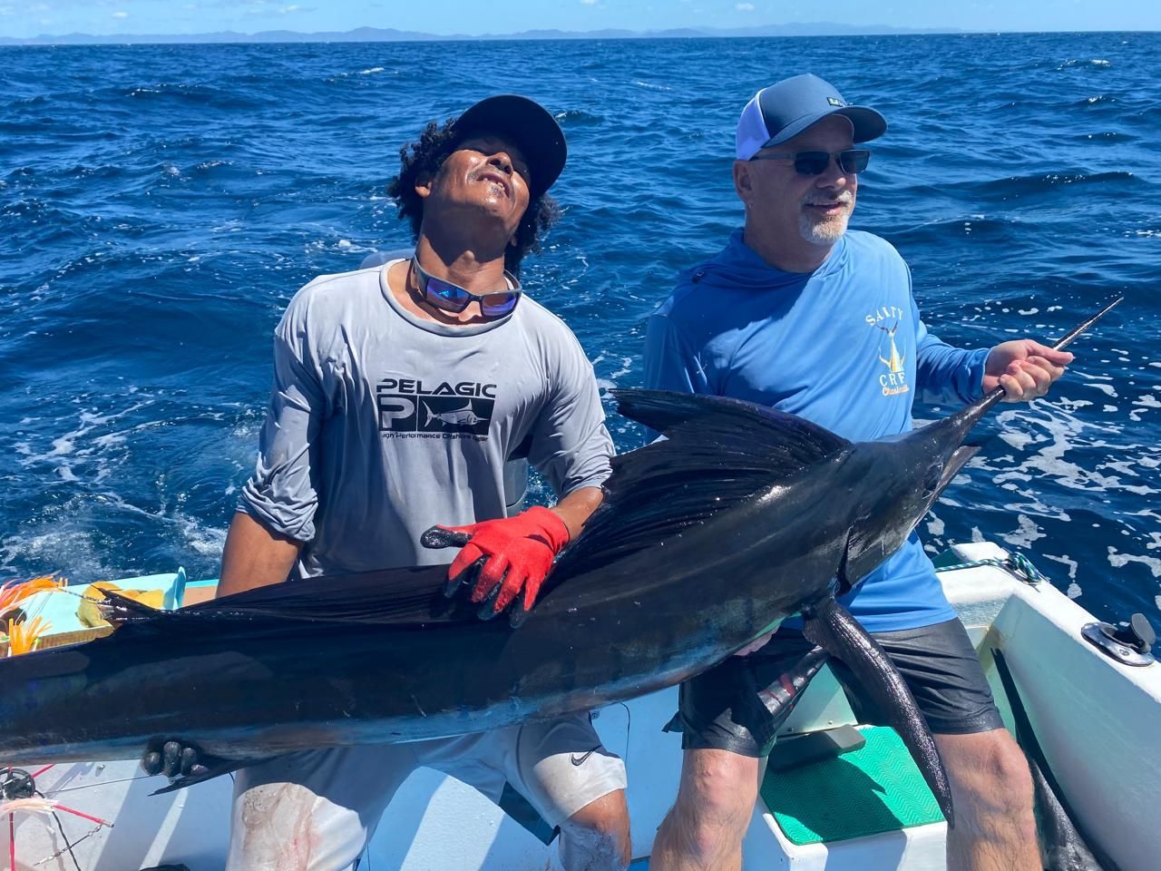 Anglers displaying a large sport fish during a private fishing charter off Guanacaste's Pacific coast in Costa Rica.