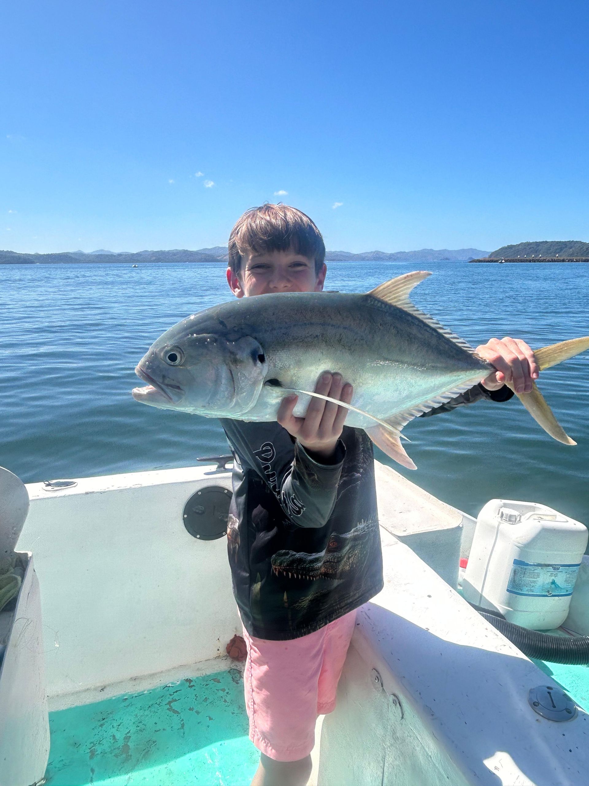 Young angler holding his catch during a private fishing charter along the Pacific coast of Guanacaste, Costa Rica.