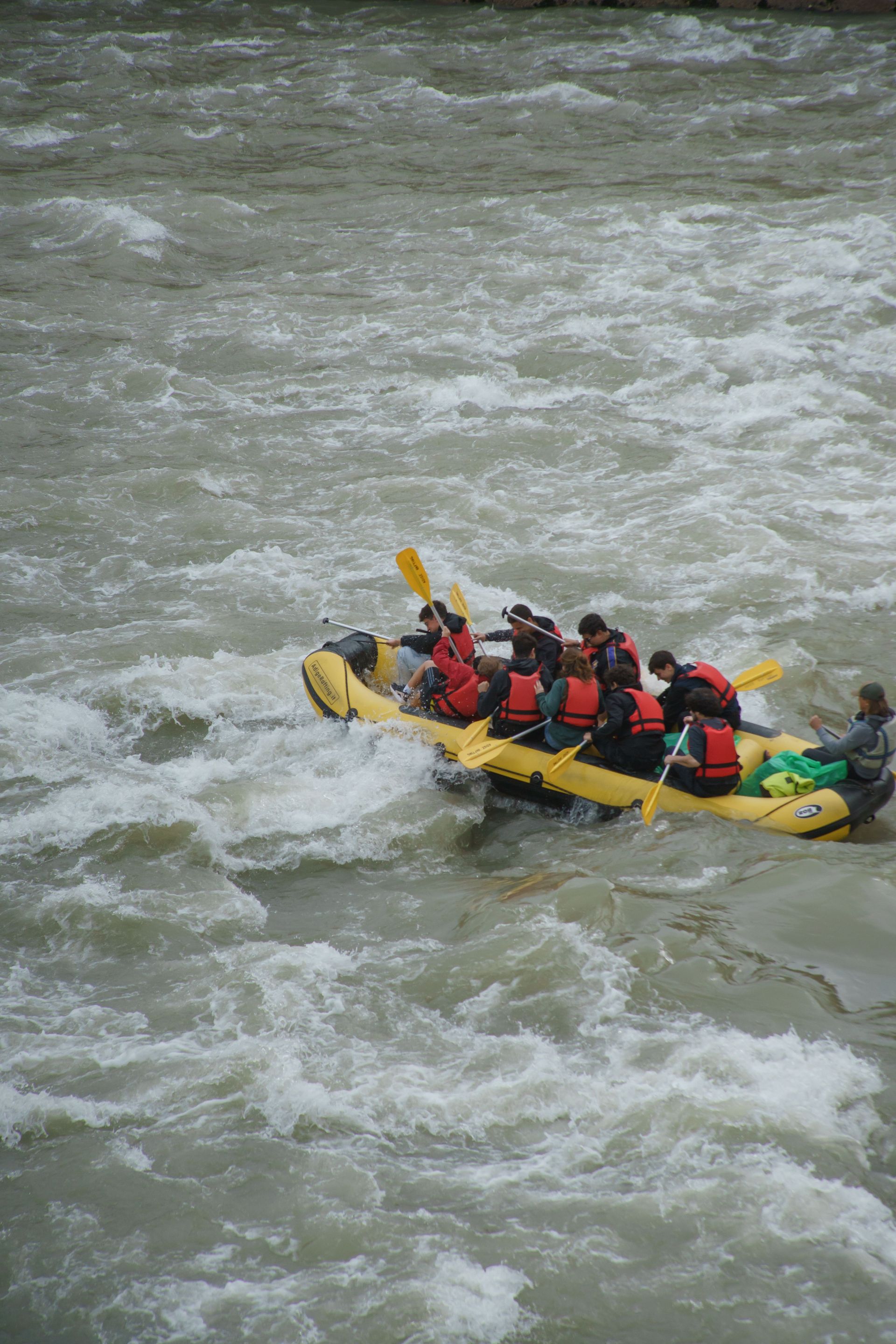 Travelers paddling through powerful white water rapids during an exciting rafting adventure tour in Costa Rica