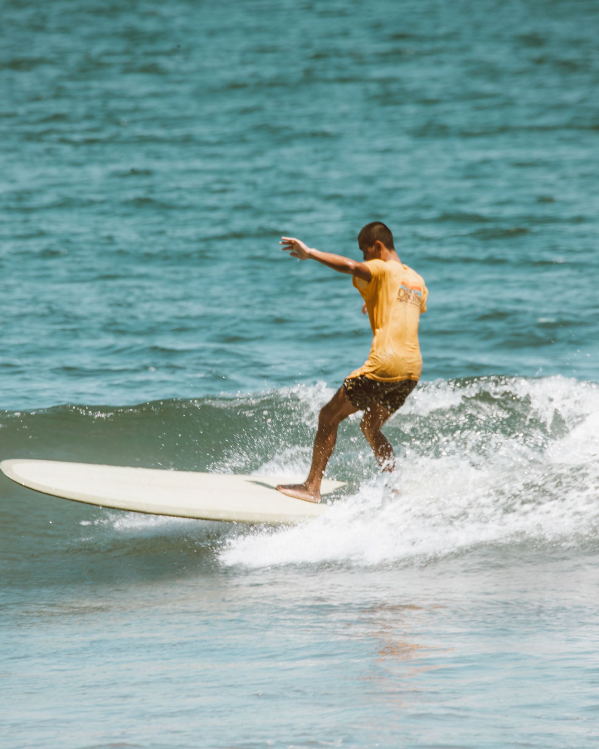 Surfer riding a Pacific Ocean wave during a surfing adventure in Tamarindo Costa Rica.