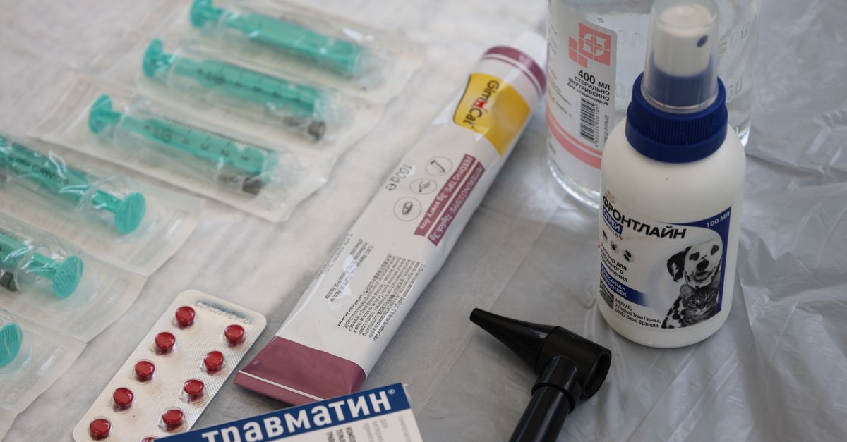 Jeringas, pastillas y frascos médicos de diversos tipos dispuestos sobre una tela blanca.