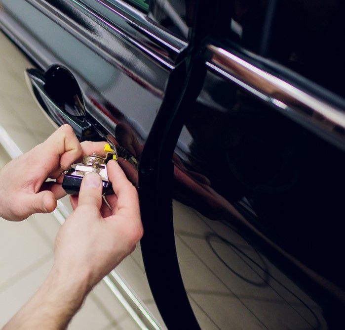 A Person Is Opening a Car Door with A Key — Tropical Locksmiths in Airlie Beach, QLD