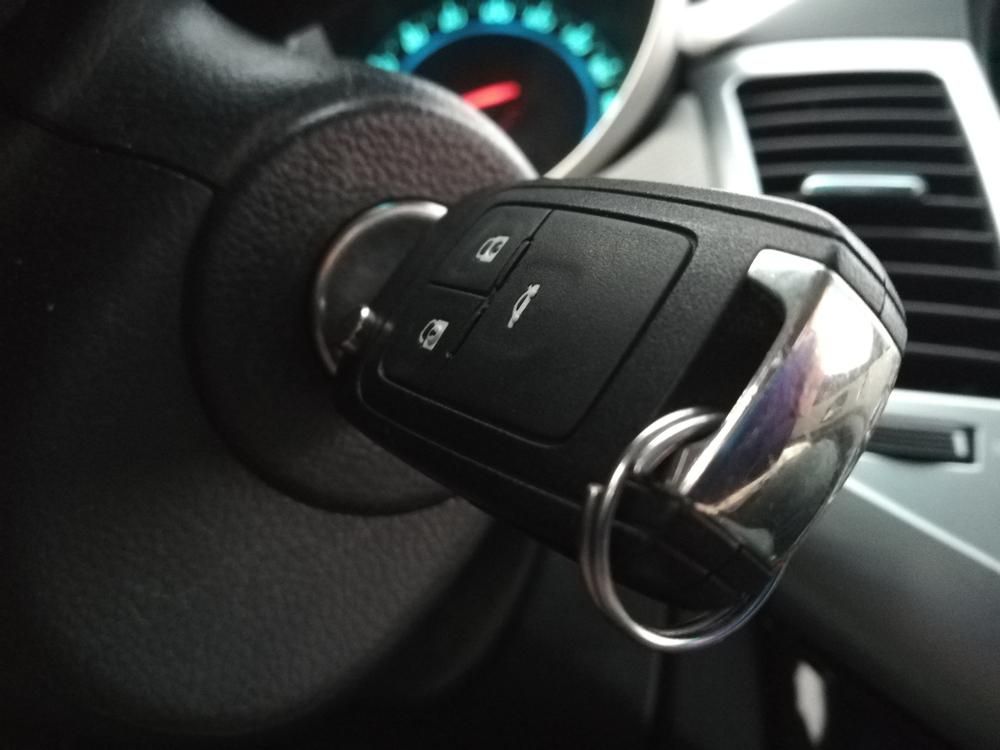 A Car Key Is Sitting on The Steering Wheel of A Car — Tropical Locksmiths in Gregory River, QLD