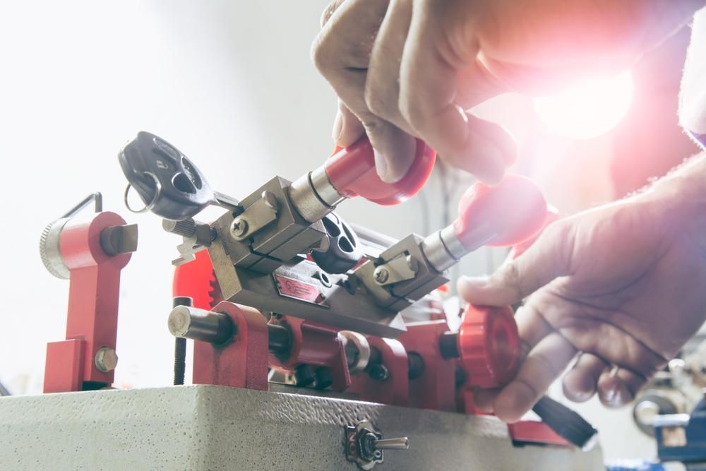 A Person Is Using a Machine to Make Keys — Tropical Locksmiths in Gregory River, QLD
