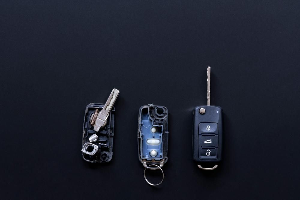 Three Car Keys Are Sitting on A Black Surface — Tropical Locksmiths in Proserpine, QLD