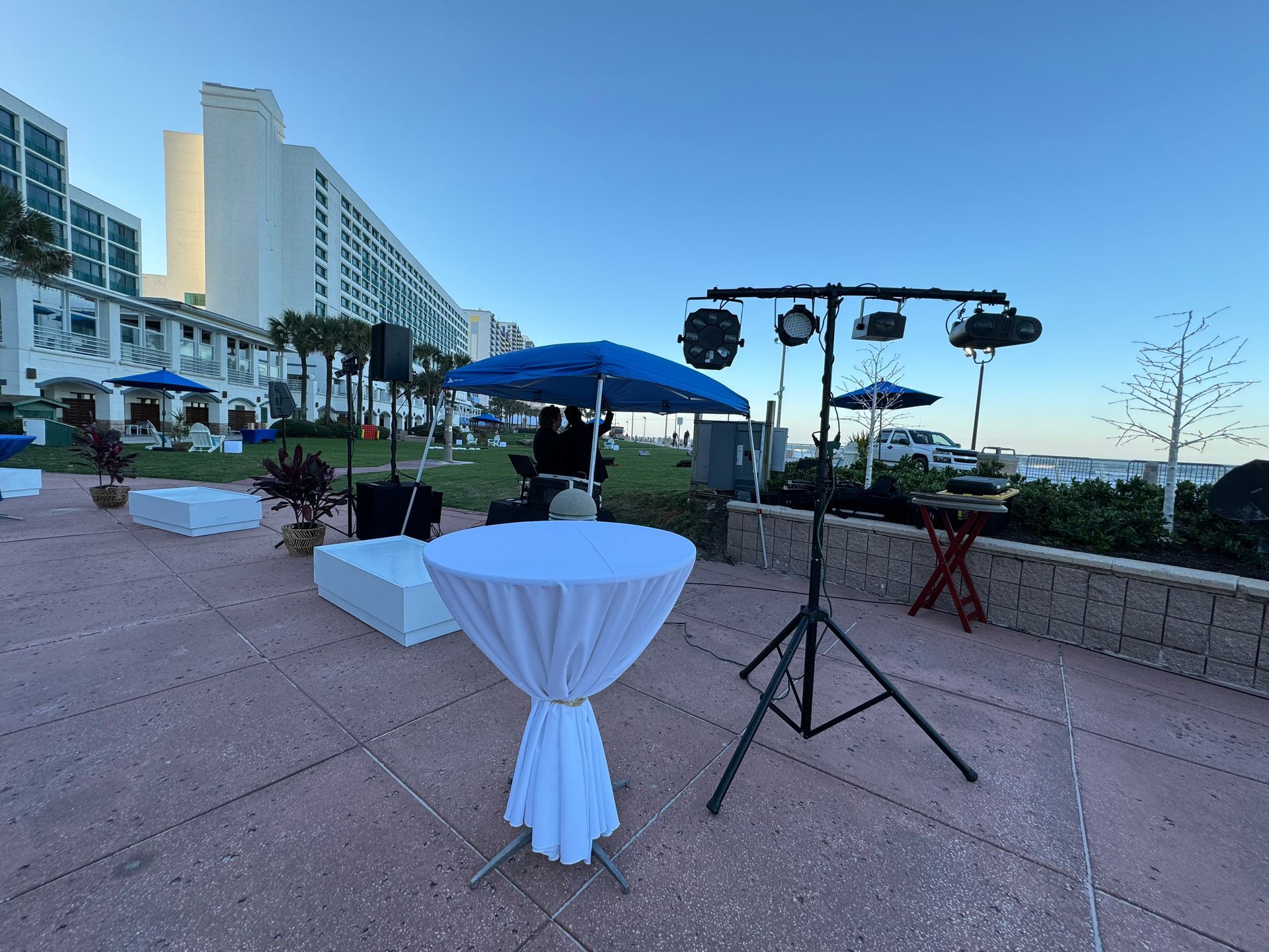 Blue and white tables with black plastic chairs at a beach themed event 